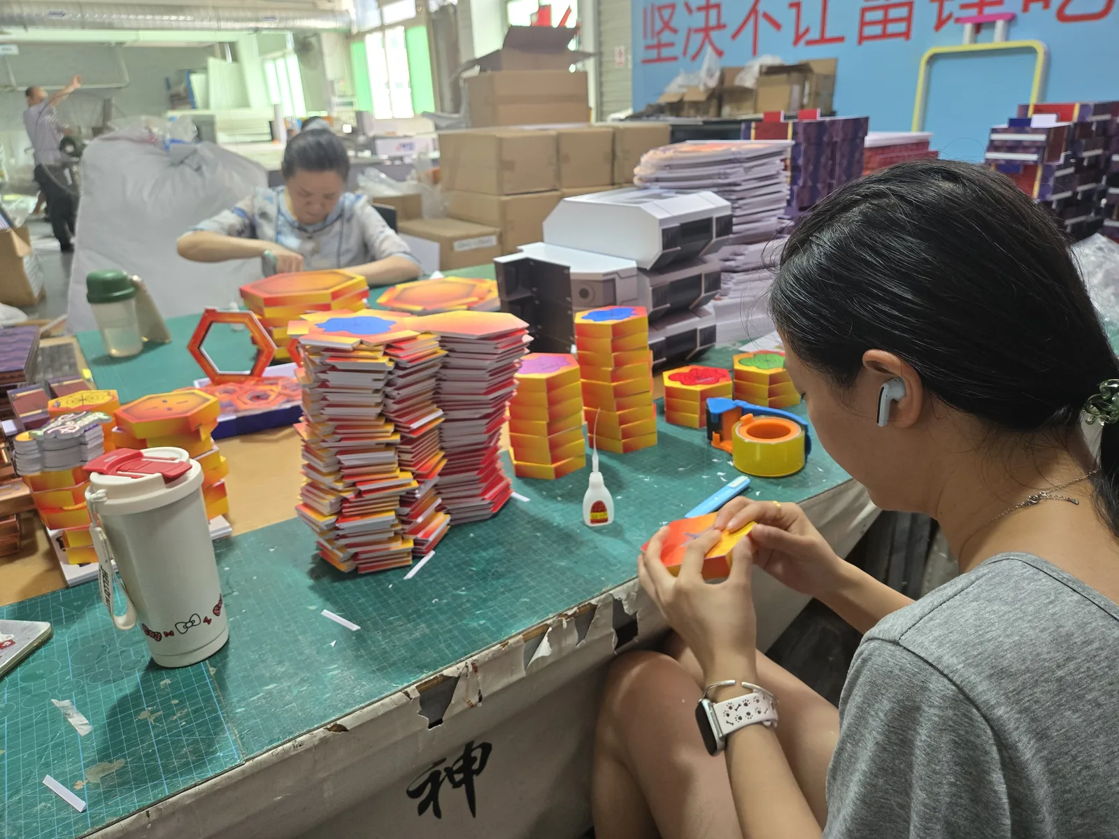 Factory staff manually assemble components for store materials.