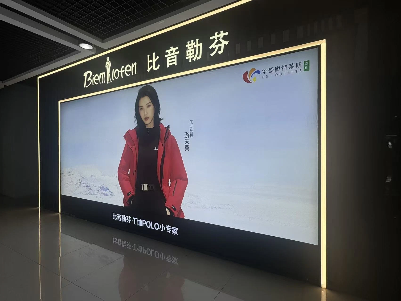 Shopfront fabric lightbox below the Biemlofen sign, featuring model You Tianyi and the HS Outlets Shenzhen logo