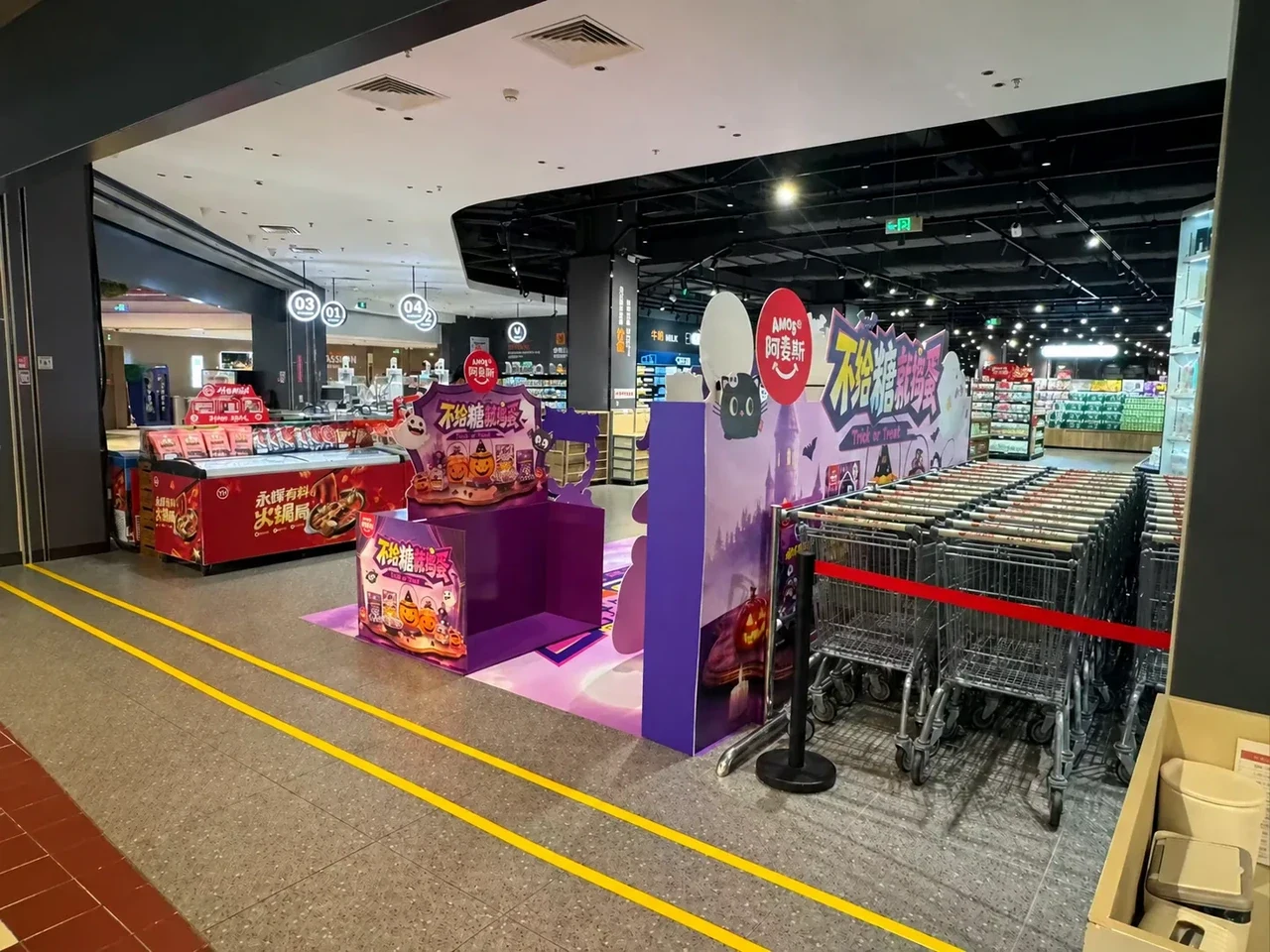 Side-rear view of the Halloween promotion zone showing the backdrop profile and a second display unit next to the trolley bay