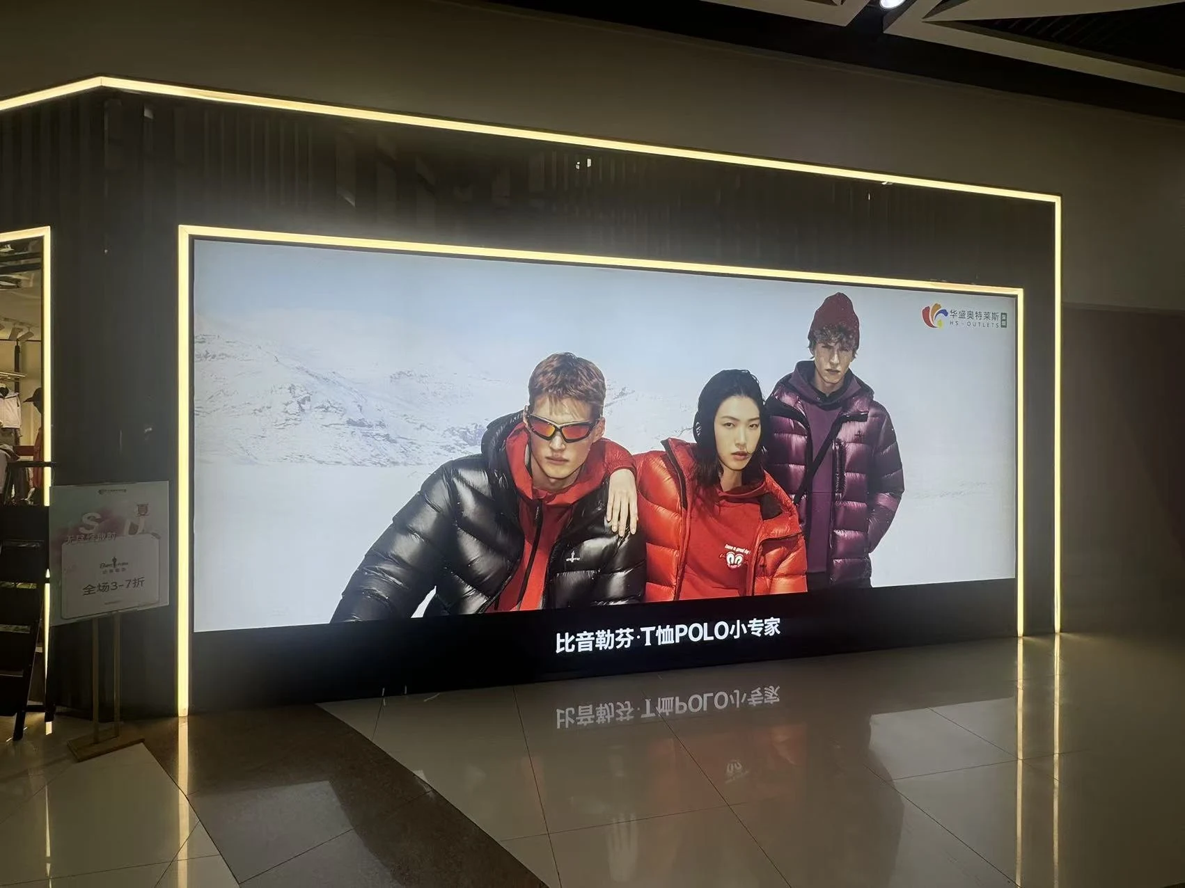 Extra-large fabric lightbox on the Biemlofen shopfront at HS Outlets, Shenzhen, showing three models in down jackets